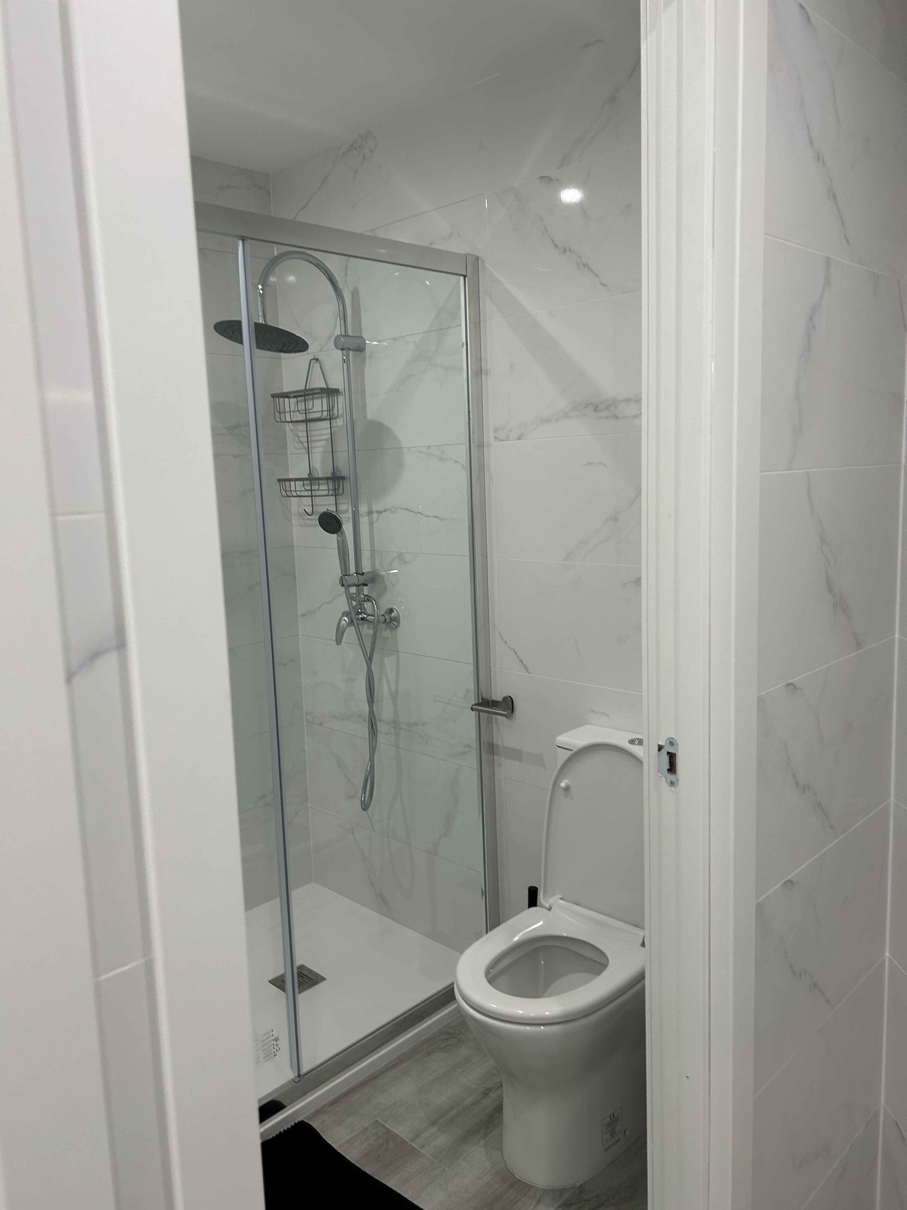 Baño principal con azulejos efecto mármol