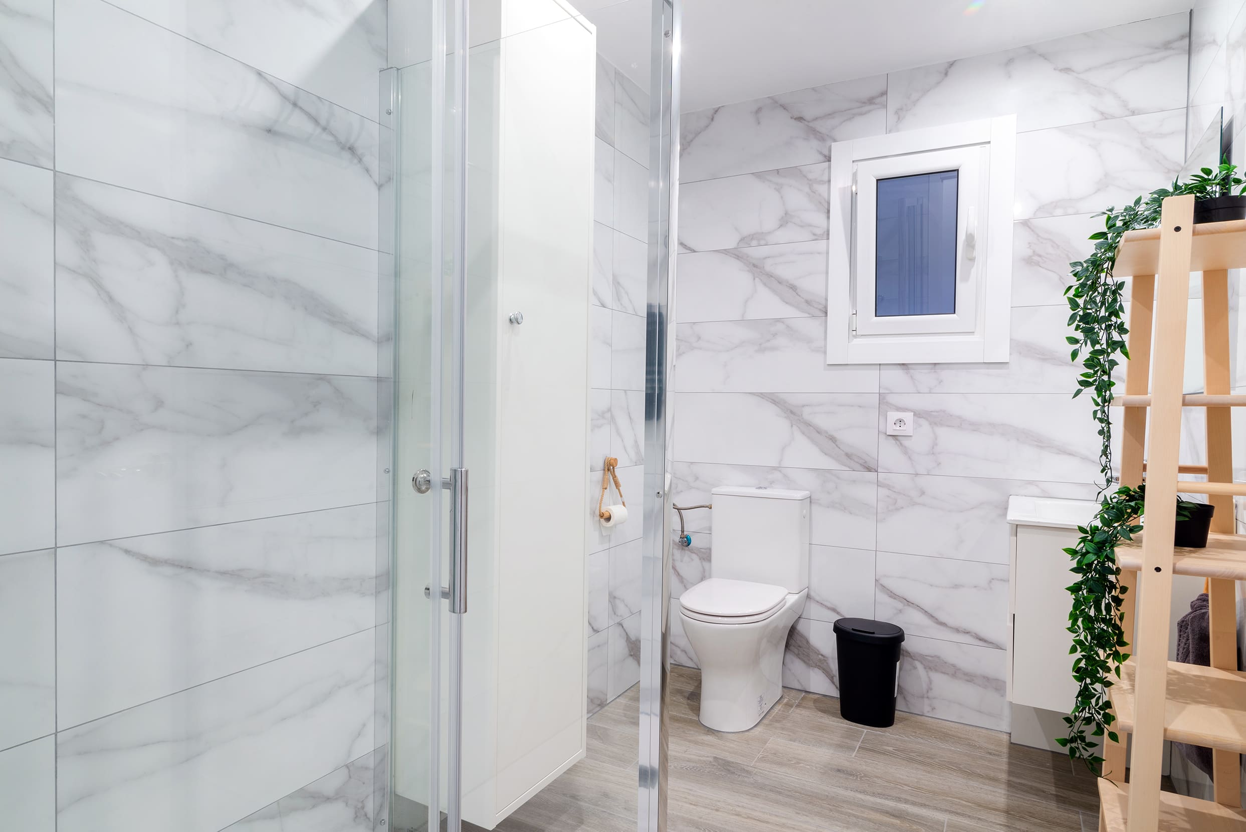 Baño con inodoro y azulejos de mármol