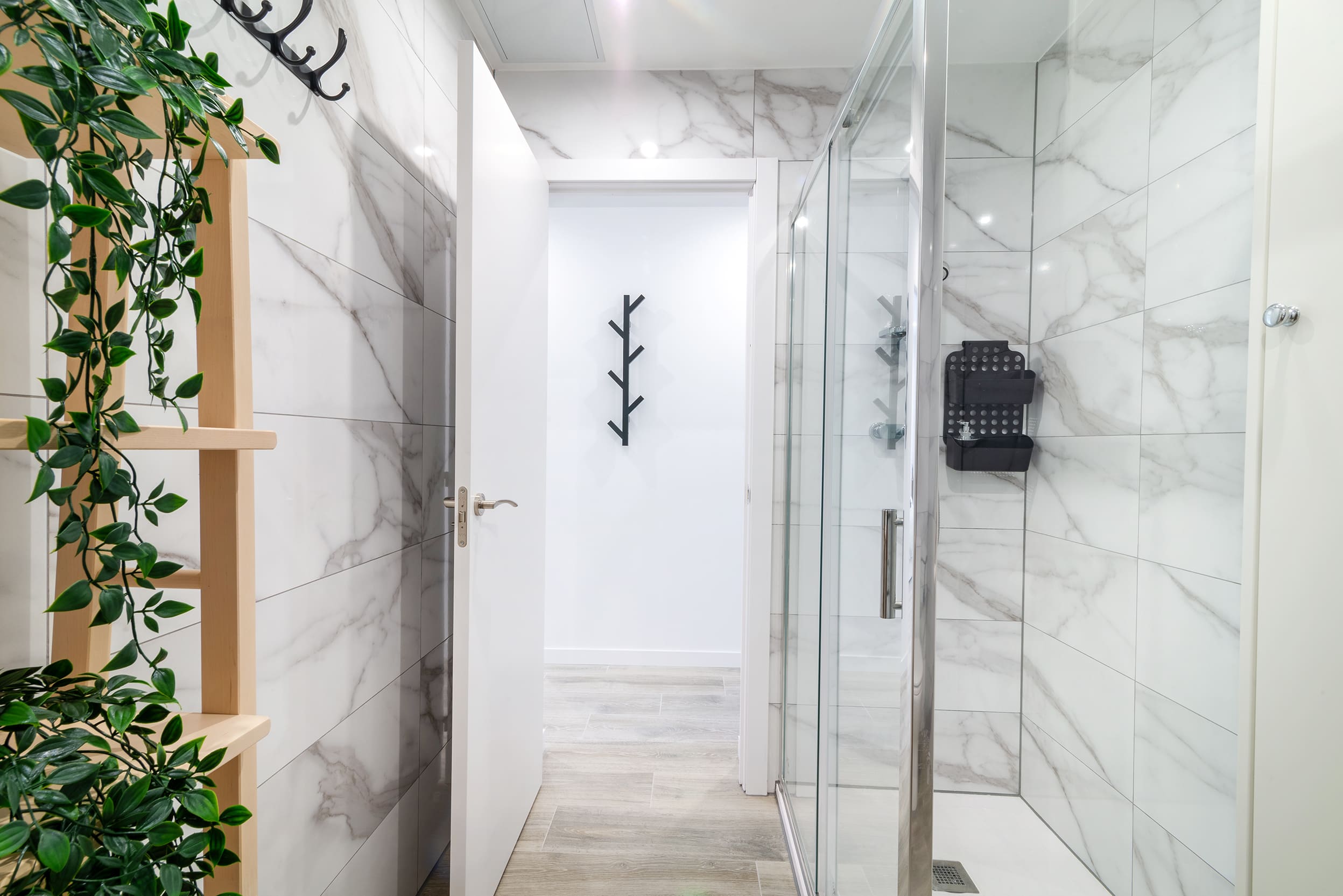 Baño con azulejos de mármol y ducha de cristal